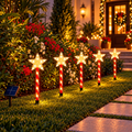 Juego de cinco bastones navideños con estrellas LED cálidas junto a una entrada; ambientación ilustrativa