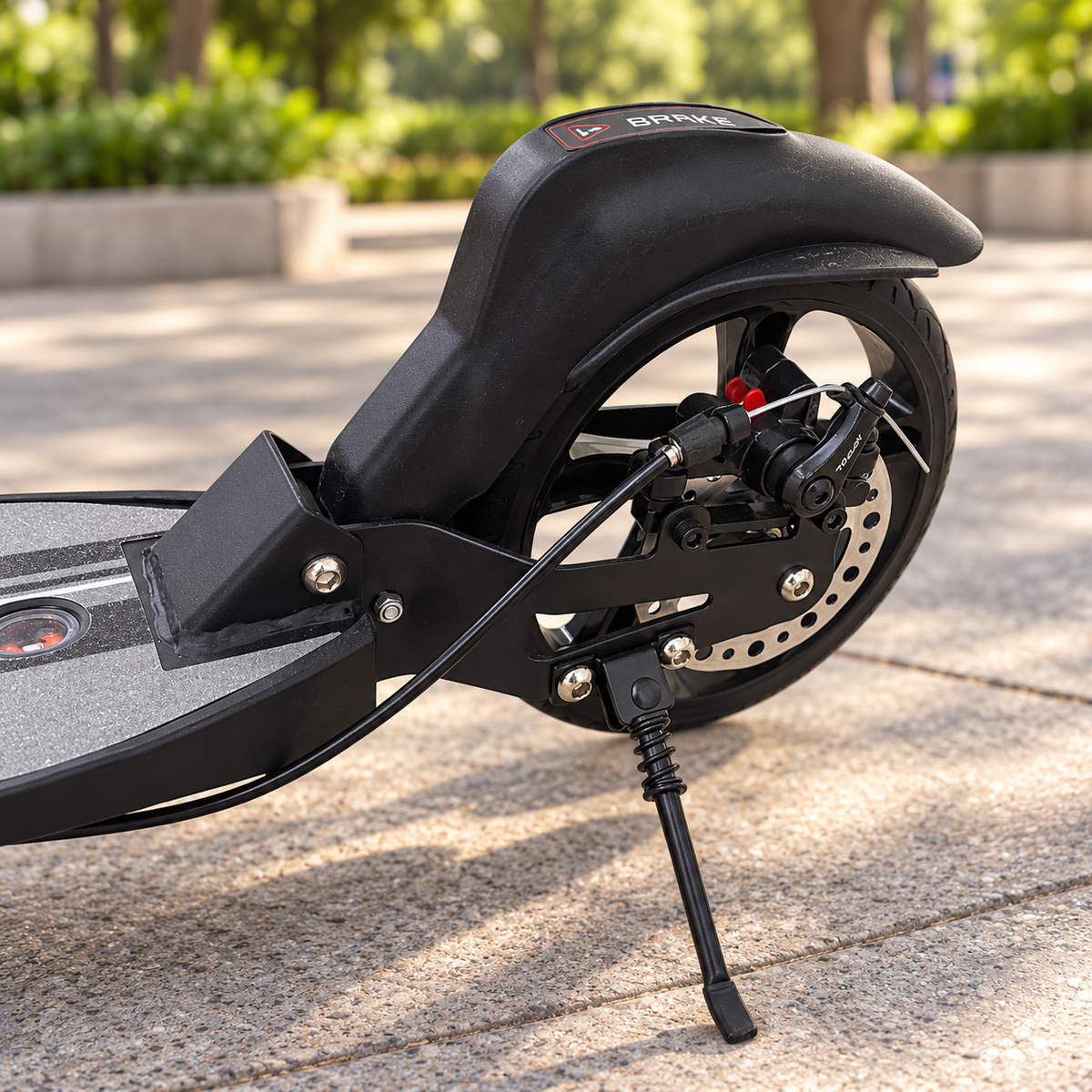 Detalle del freno de disco trasero y soporte de pie de la scooter